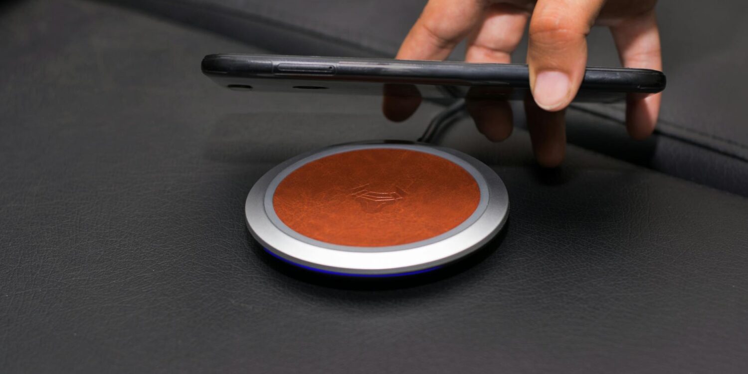 close up of person putting smartphone on wireless charger