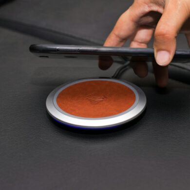 close up of person putting smartphone on wireless charger