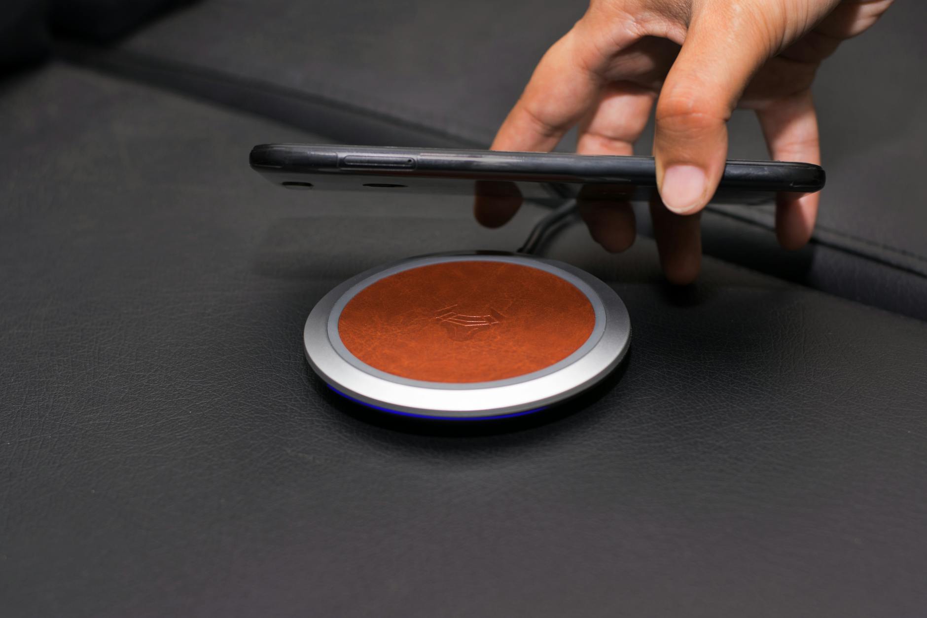 close up of person putting smartphone on wireless charger